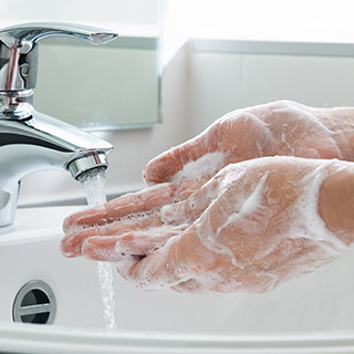 Photo of person washing their hands with soap and water