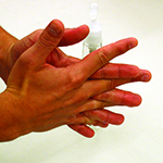 Photo of person spreading sanitizer between fingers