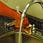 Photo of person turning off faucet with a paper towel