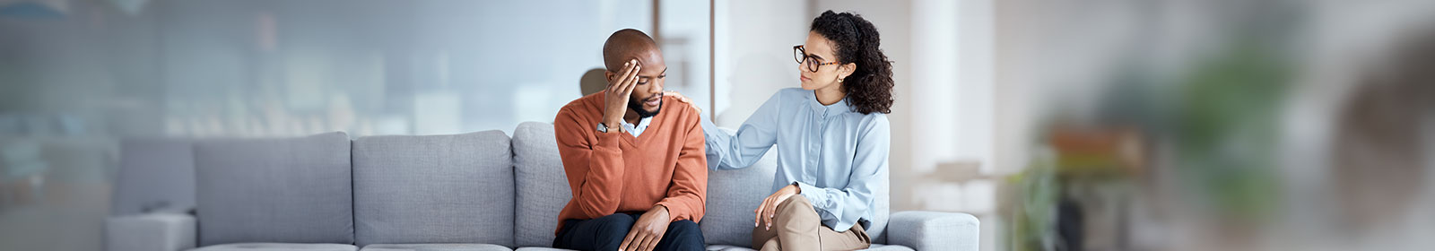 Two people sitting on a couch talking 