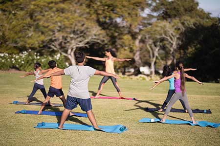 Group of youths doing yoga outdoors