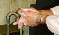 A person lathering their hands and wrists with soap.