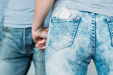 Backview of a woman with a contraceptive in her jeans pocket