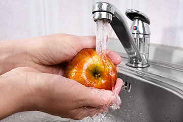 Photo of a person washing an apple