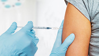 Photo of person receiving immunization shot in arm