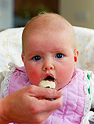 A baby being spoon fed baby cereal.