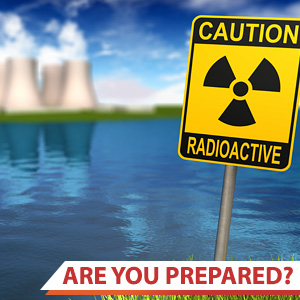 Photo of a caution: radioactive sign with a nuclear power plant in the background